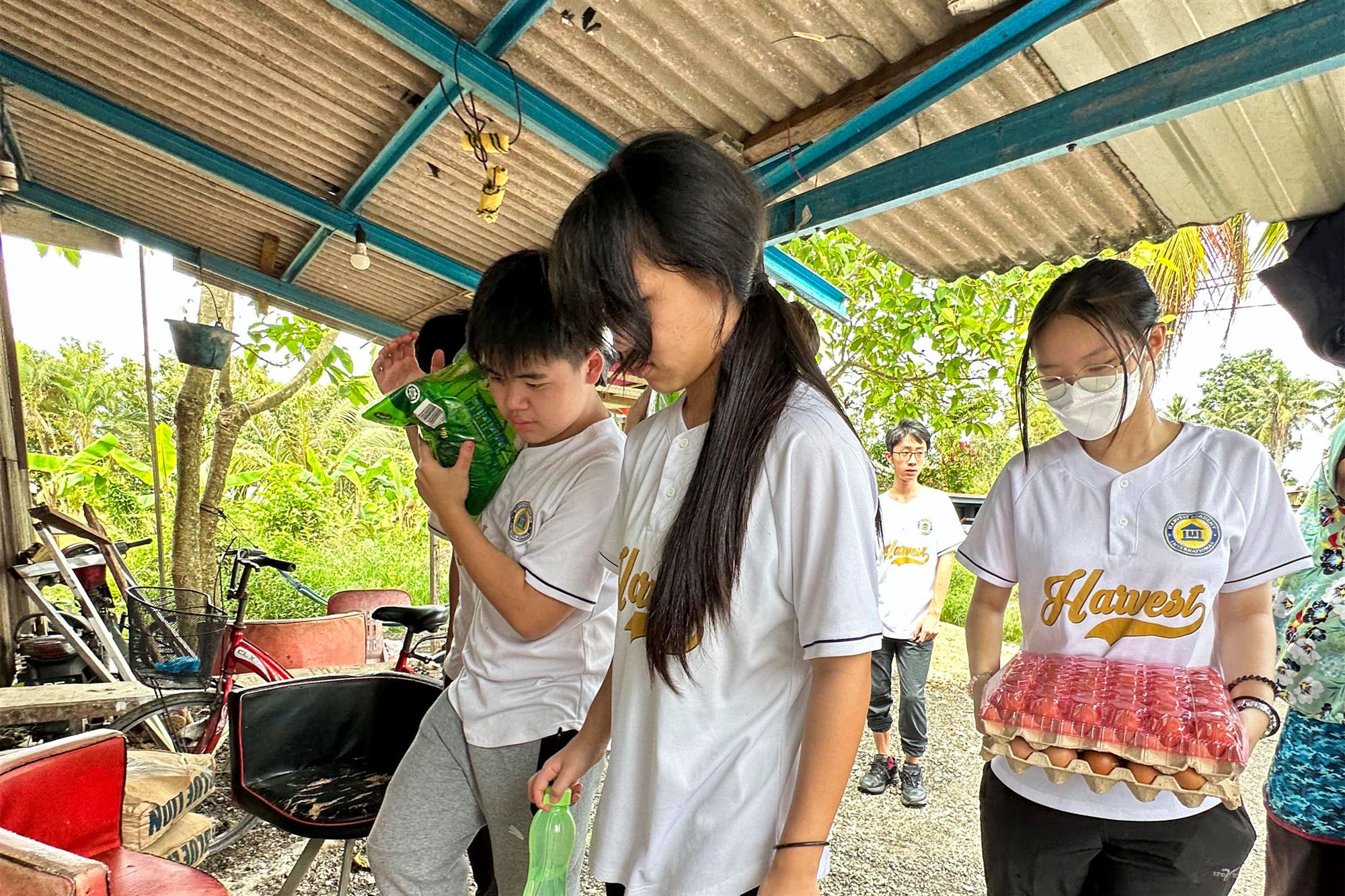 Harvest Academy students delivering essential supplies to a local household