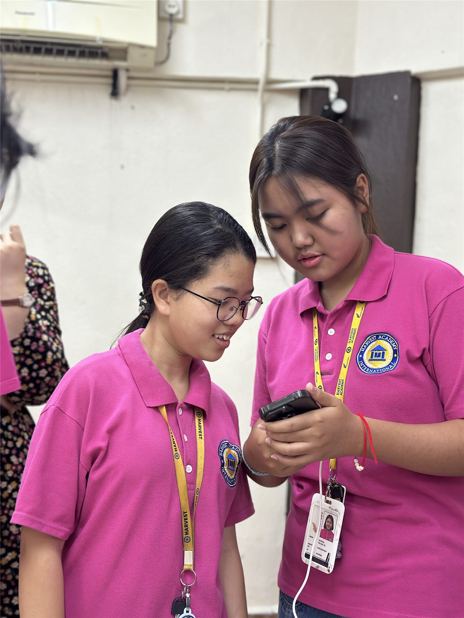 A senior Harvest Academy student guiding a younger student